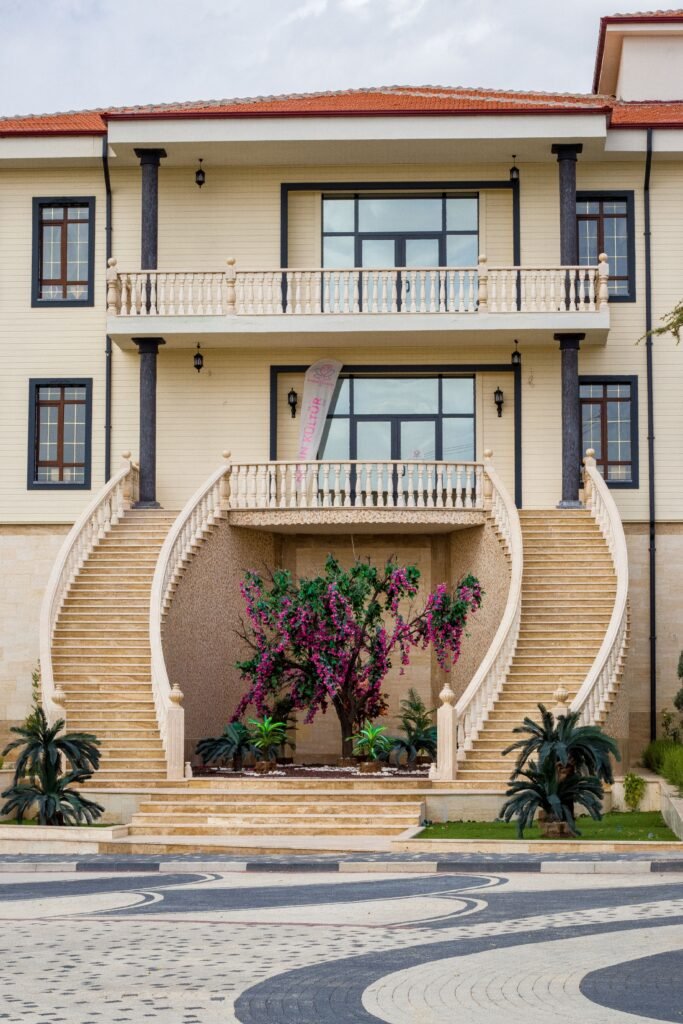 Grand mansion featuring a curved staircase and floral arrangement, perfect for luxury themes.